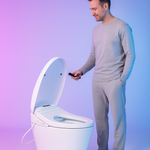 Homme avec une télécommande d'utilisation devant une toilette japonaise 