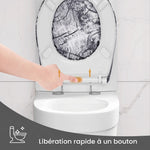 Un abattant WC forme O et gris avec motif bois avec un doigt qui appuie sur le bouton de déclipsage rapide pour l'enlever 