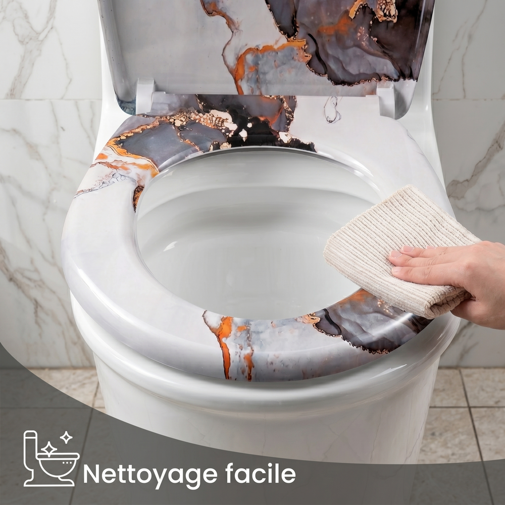 Une main avec une chiffon qui nettoie la surface lisse d'un abattant WC en marbre 
