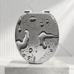 Un abattant WC forme O gris avec motif de goutes d'eaux et des charnières en acier inoxydable 